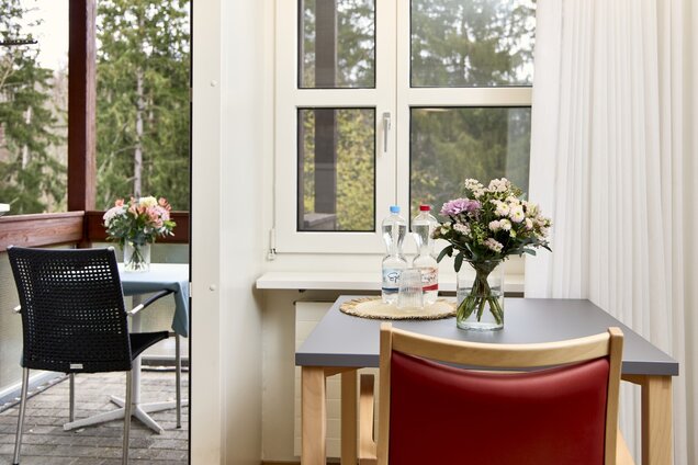 Schreibtisch am Fenster, geöffnete Balkontür mit Aussicht